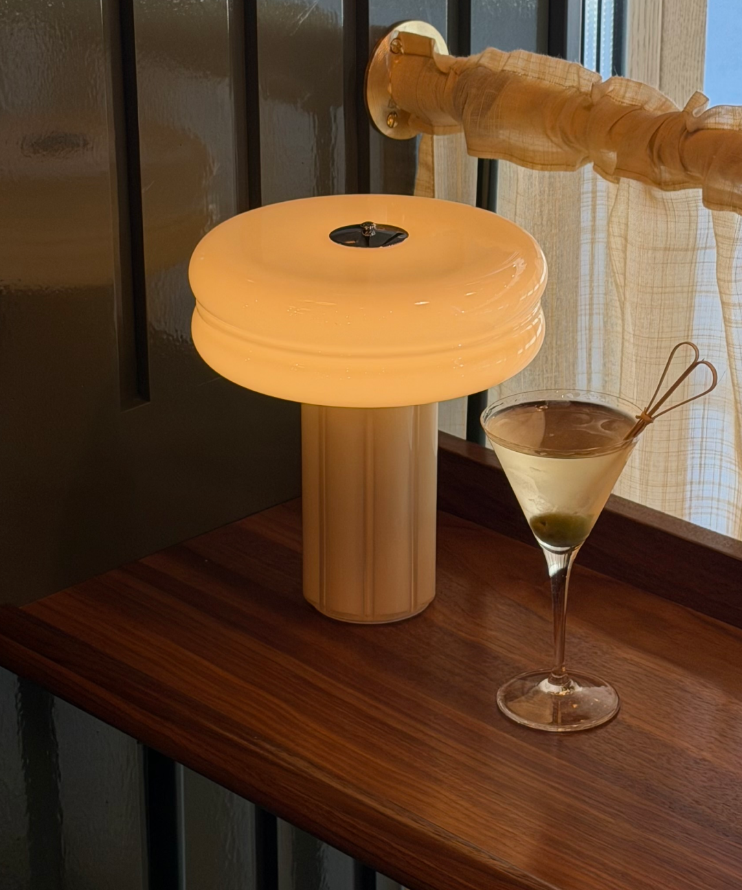 The Affiné Portable Lamp in Crème Beige creating a warm evening glow.