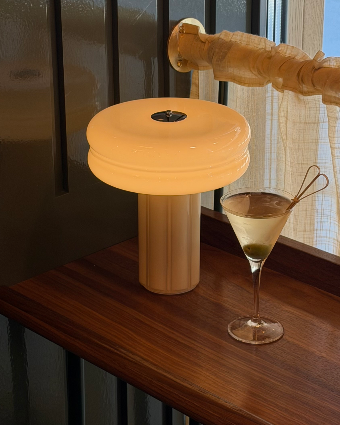 The Affiné Portable Lamp in Crème Beige creating a warm evening glow.