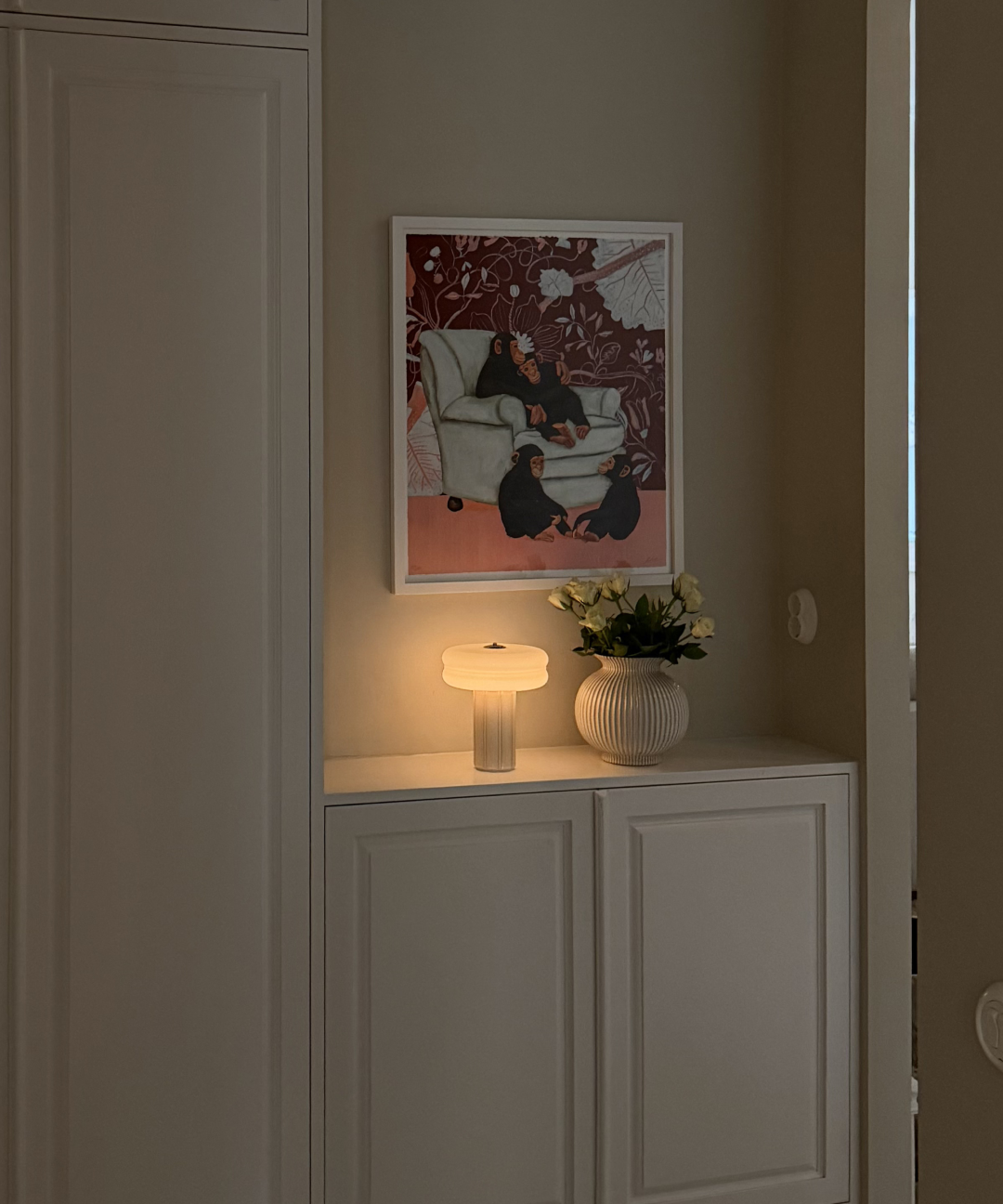 Affiné Portable Lamp in Crème Beige styled on a sideboard.