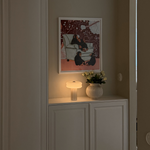 Affiné Portable Lamp in Crème Beige styled on a sideboard.