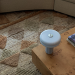 Close-up of the Affiné Portable Lamp in Powder Blue on a table.
