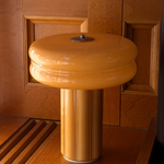 Affiné Portable Lamp in Soft Amber placed by a wooden-framed window.