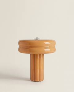 The Affiné Portable Lamp in Soft Amber – hand-blown glass with polished aluminium top.