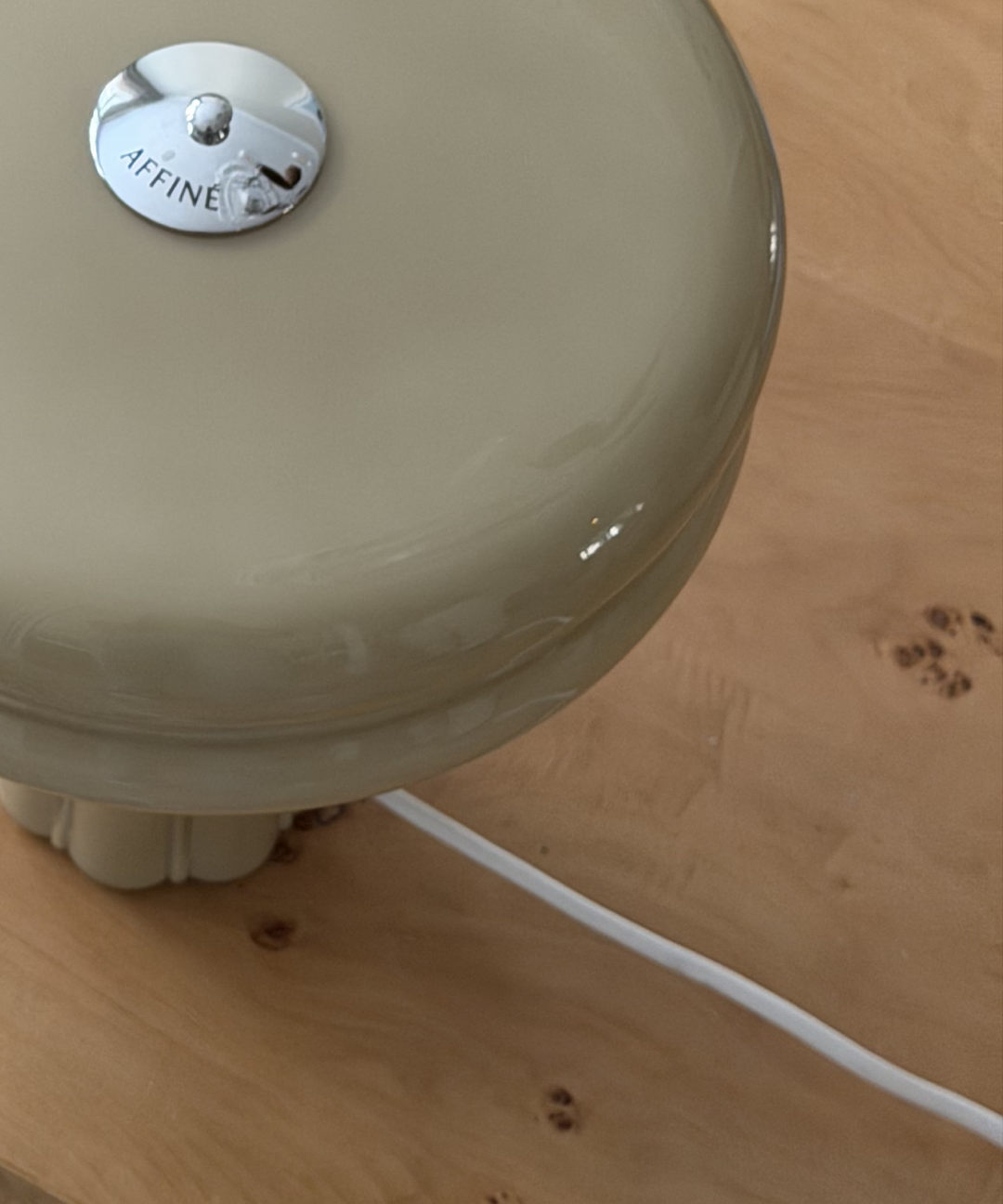 Close-up of the Affiné Table Lamp in Sage Green on a table.