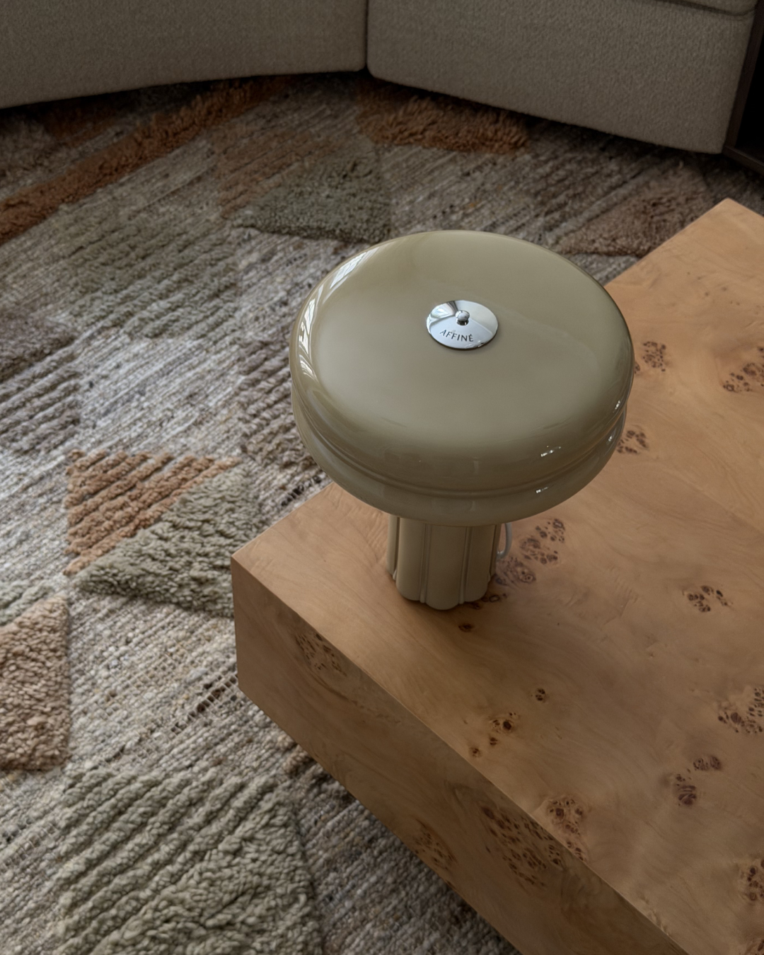Affiné Table Lamp in Sage Green styled on a table.