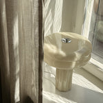 Close-up of the hand-blown glass on the Affiné Table Lamp in Crème Beige.