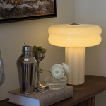 Affiné Table Lamp in Crème Beige styled on a dark wooden sideboard.